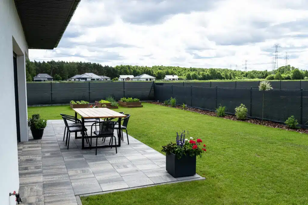 Vue d'une terrasse moderne avec carrelage gris et mobilier de jardin.